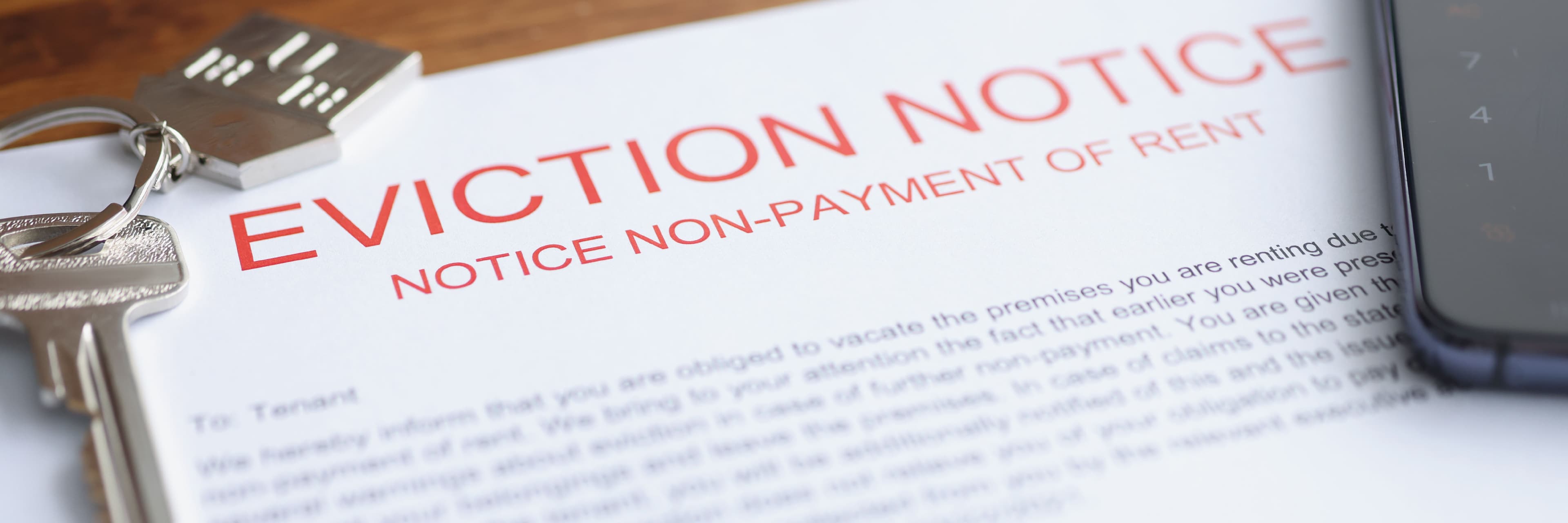 Eviction notice for non-payment of rent alongside house keys, illustrating the process of evicting a tenant and regaining possession of a rental property.
